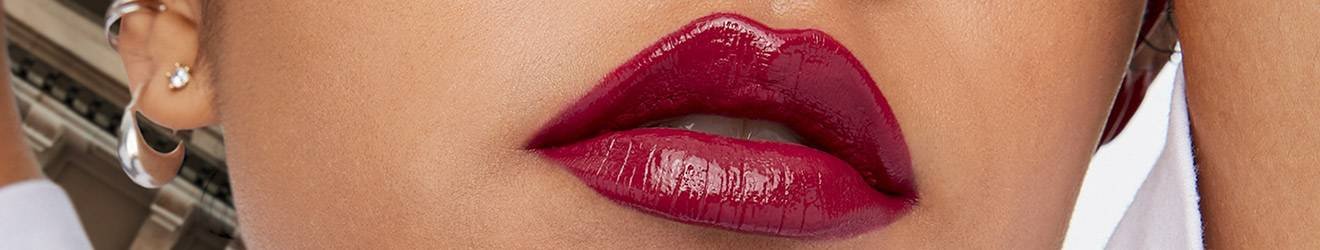 Maybelline Lipstick products illustrative banner image - Close up of woman wearing bright lipstick